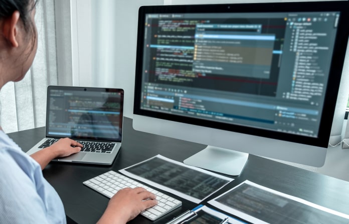 複数のモニターでシステム開発を行うエンジニア